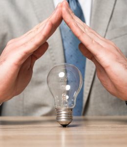 Hands tented over a lightbulb.