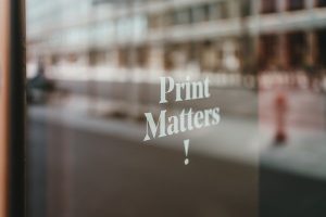 blurred office building with fire hydrant in front and Print Matters imposed on top of the picture