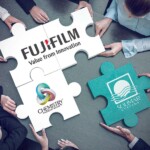 large puzzle pieces with FujiFilm printed across two pieces and one with Chemistry logo all interlocked and one green with Solimar logo being locked in