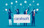 Two women and two men holding sign with Carahsoft on it