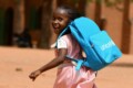 Happy child with a Unicef backpack going off to school