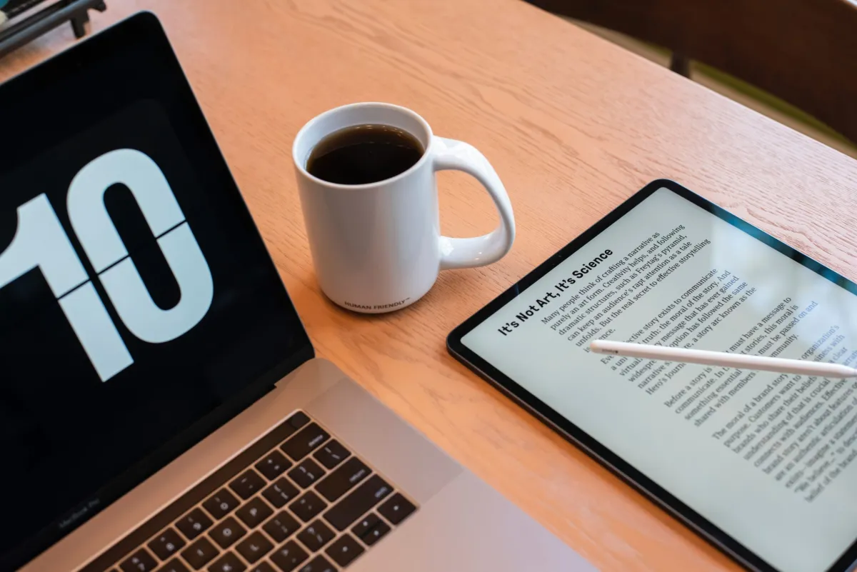 Laptop, cup of coffee and a tablet all on a table