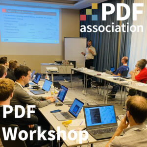 People seated around a conference table with laptops listening to Peter Wyatt speak from the end of the table.