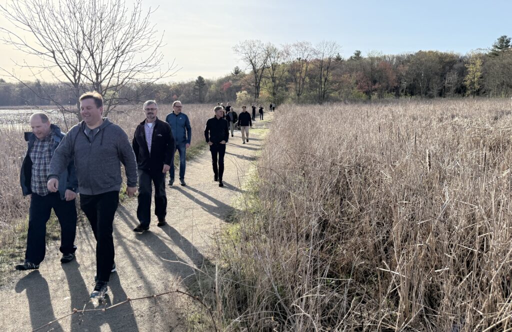 PDF Week attendees on a morning walk through a meadow.