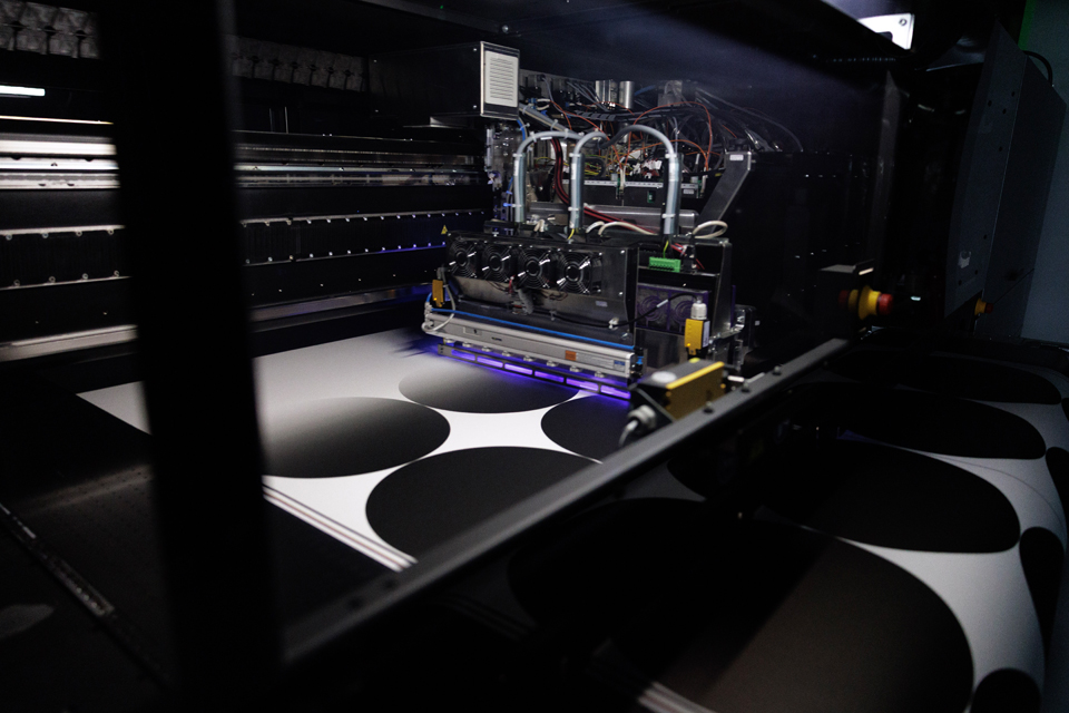 Industrial printer producing black-and-white patterned wallpaper.